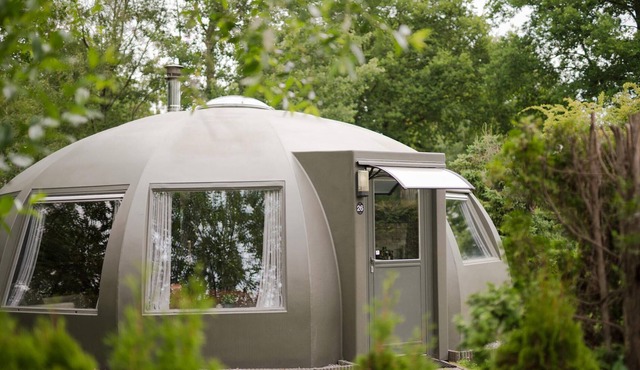 These detached bungalows with domed roofs are scattered in a wooded resort.