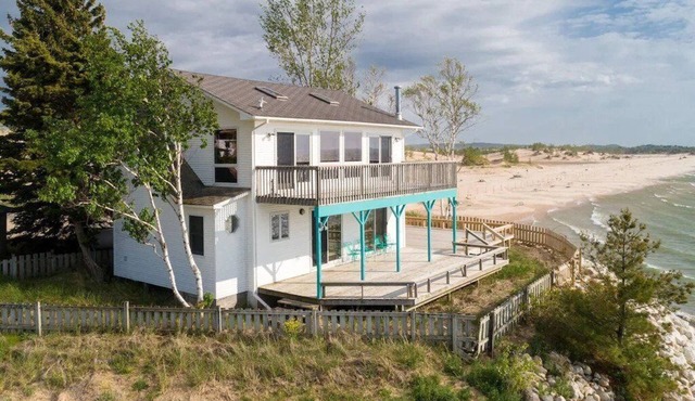 This charming vacation home sits directly on Lake Michigan and it delivers!
