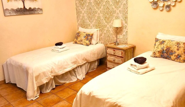 This room has two single beds with an en-suite bathroom. The room looks onto the road and has mountain views to the rear of the building.