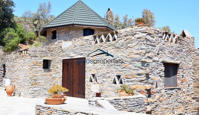 Traditional stone built villa with a windmill and a swimming pool in Koundouros