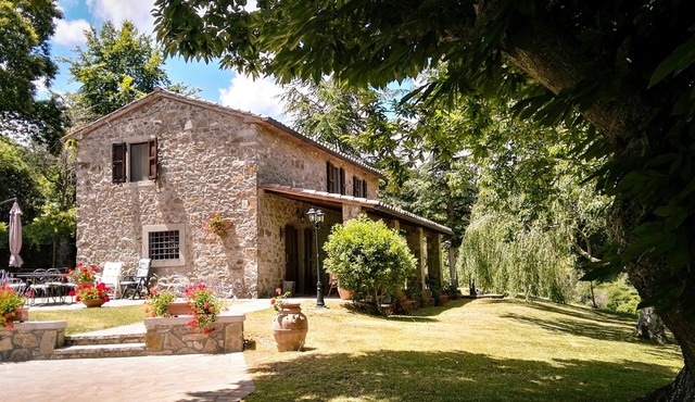Tuscan stone villa with private pool surrounded by greenery