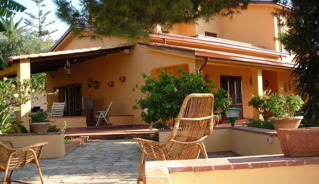 Villa 'The Plumbaco' with a large veranda and lush garden. At 5 minutes from the sea