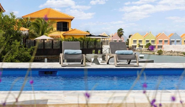 Waterfront villa with terrace, SUP boards, barbecue, and access to a shared swimming pool.